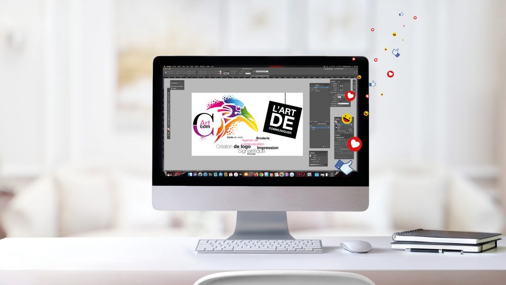 Logo de l'entreprise C-artcom qui représente un oiseau stylise et tres colore. Acoompagné d'un slogan: l'art de communiquer. Le tout est disposé sur un ordinateur dans un endroit lumineux et reposant.